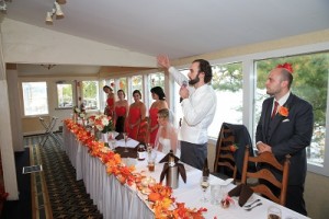 Groom holds microphone as he addresses his guests from the head table on his wedding day.