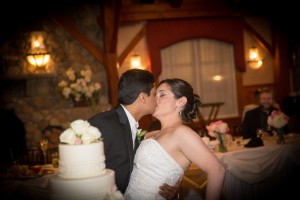 Rueben and Andrea share a kiss in front of their wedding cake