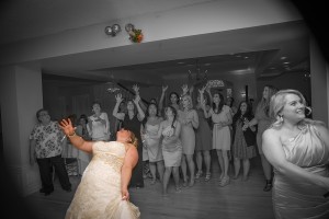 Black and white - Bride tosses bouquet - Only the bride and the bouquet are in color.
