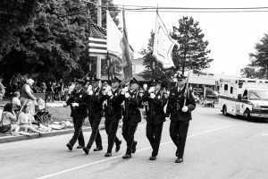 Six Billerica Police Officers in full dress blues carry flags as they march in Billerica's Memorial Day Parade