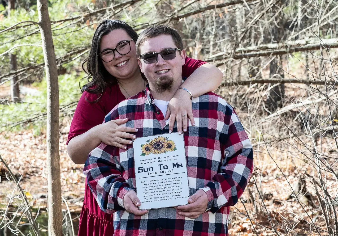 A man and woman holding up a sign.